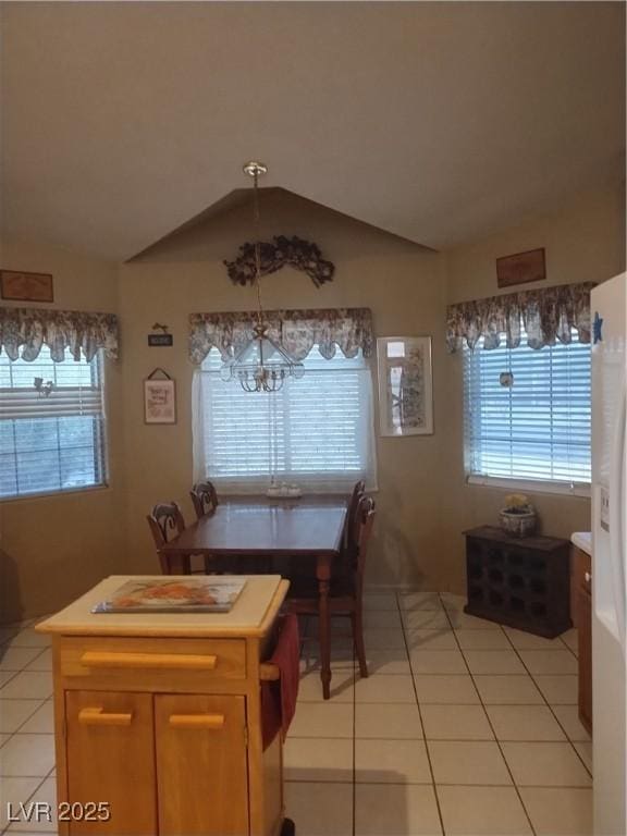 7894 W Patrick Ln, Las Vegas, NV 89113 - dining area featuring a chandelier, light tile patterned floors, vaulted ceiling, and plenty of natural light