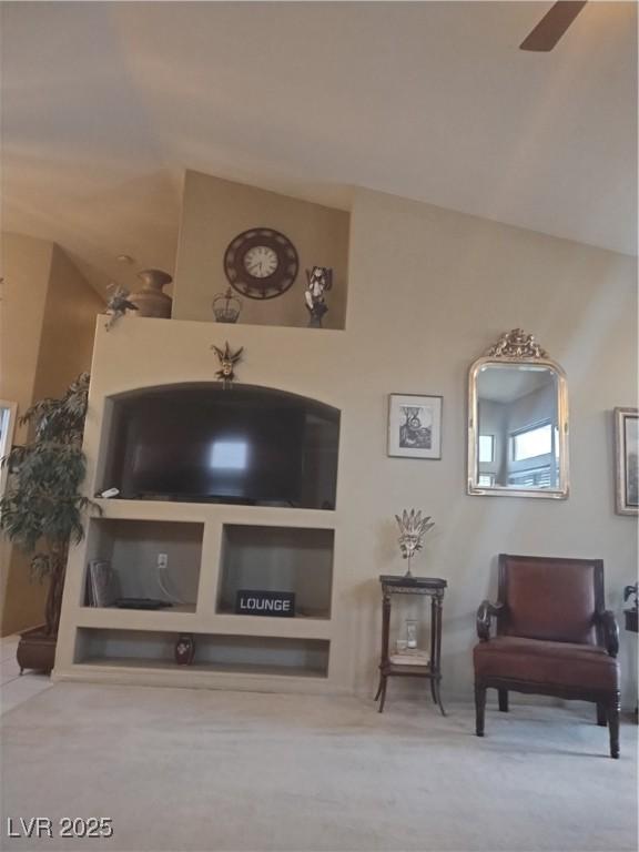 living area featuring carpet and a ceiling fan
