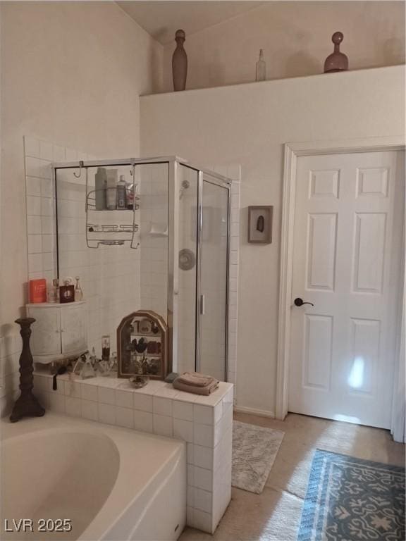 bathroom with a shower stall and a bath
