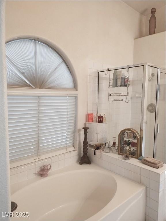 full bathroom featuring a stall shower and a bath