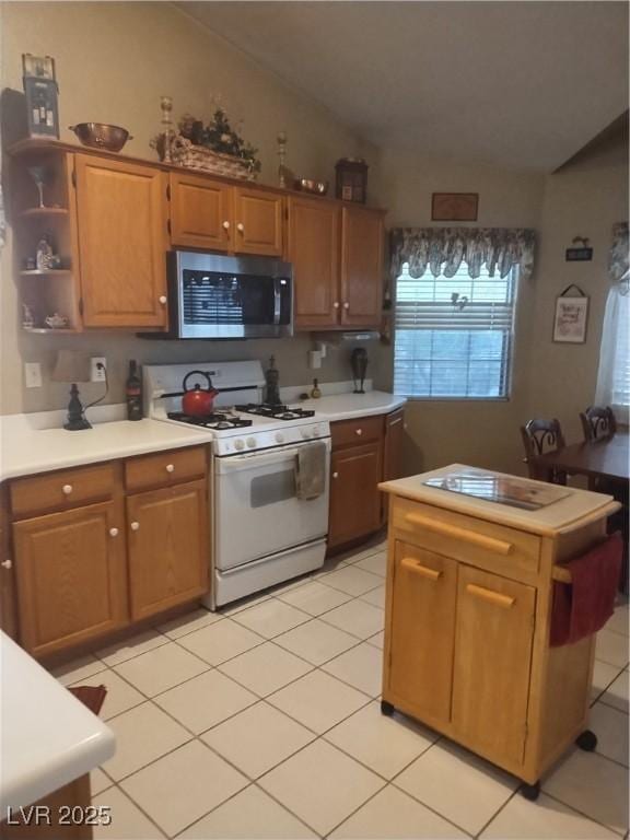 7894 W Patrick Ln, Las Vegas, NV 89113 - kitchen featuring gas range gas stove, stainless steel microwave, vaulted ceiling, light countertops, and light tile patterned floors