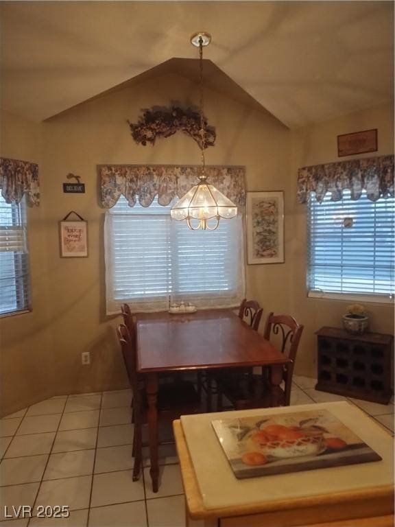 tiled dining space featuring vaulted ceiling