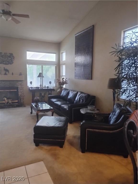 carpeted living room featuring vaulted ceiling, ceiling fan, a fireplace, and tile patterned flooring
