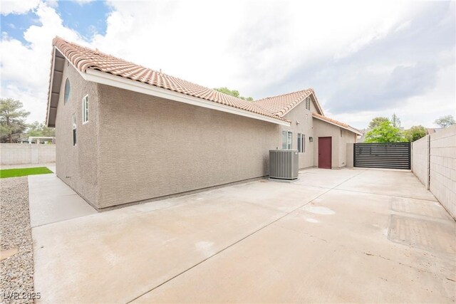 view of home's exterior with cooling unit, stucco siding, and a tiled roof