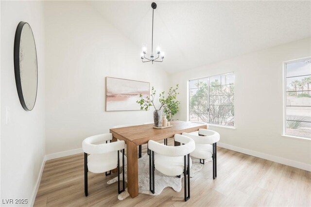 dining area with baseboards, healthy amount of natural light, a chandelier, and high vaulted ceiling
