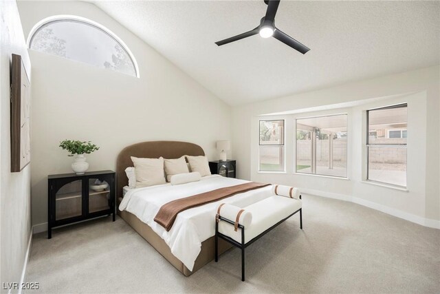 bedroom with lofted ceiling, light colored carpet, baseboards, and a ceiling fan