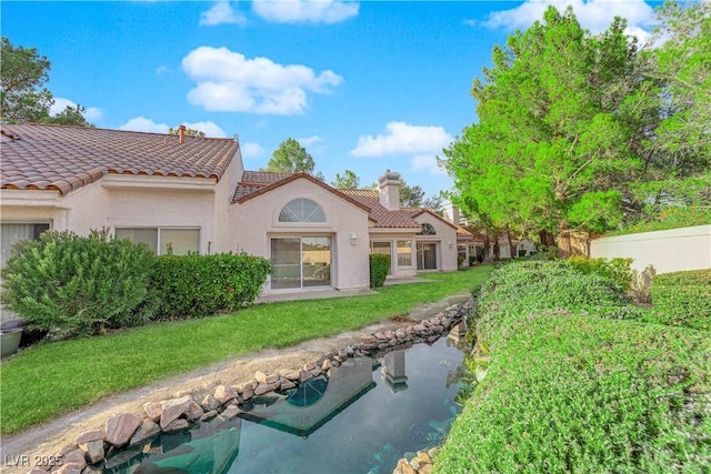 6940 Emerald Springs Ln, Las Vegas, NV 89113 - rear view of house with a chimney, a tiled roof, and stucco siding