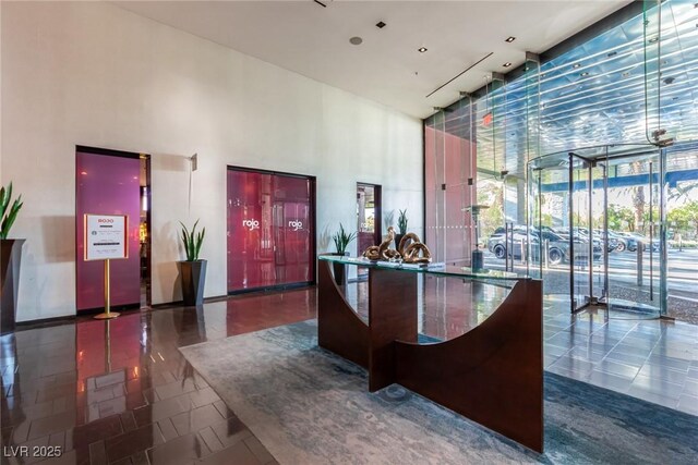 reception area featuring a towering ceiling and a wall of windows