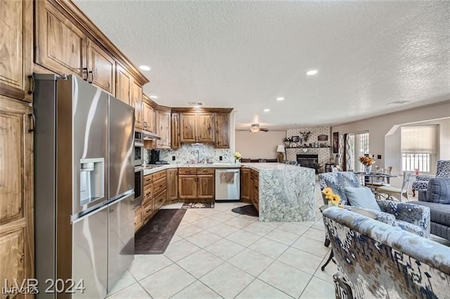 5202 Willis St, North Las Vegas, NV 89031 - kitchen featuring appliances with stainless steel finishes, open floor plan, light countertops, brown cabinetry, and recessed lighting