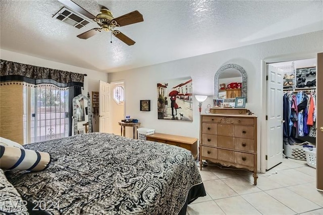 5202 Willis St, North Las Vegas, NV 89031 - bedroom featuring a textured ceiling, light tile patterned floors, ceiling fan, and a walk in closet