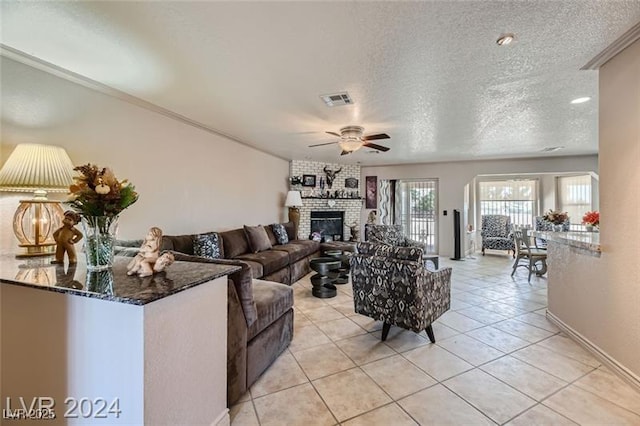 5202 Willis St, North Las Vegas, NV 89031 - living area featuring a ceiling fan, a textured ceiling, a fireplace, light tile patterned floors, and baseboards