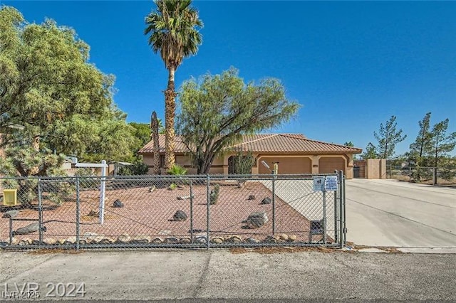 5202 Willis St, North Las Vegas, NV 89031 - view of front of home featuring a fenced front yard, driveway, a garage, a tile roof, and stucco siding
