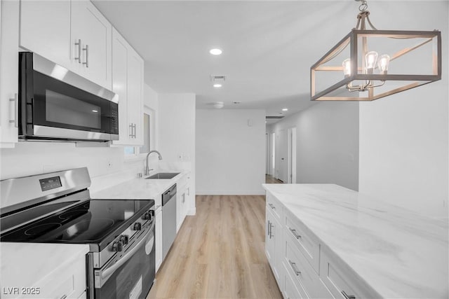 1616 Yellow Rose St, Las Vegas, NV 89108 - kitchen featuring stainless steel appliances, a sink, light wood-style floors, white cabinetry, and recessed lighting