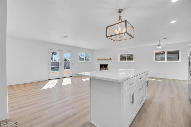 1616 Yellow Rose St, Las Vegas, NV 89108 - kitchen featuring open floor plan, light wood-type flooring, white cabinetry, a center island, and recessed lighting