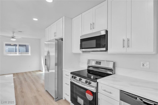 1616 Yellow Rose St, Las Vegas, NV 89108 - kitchen featuring appliances with stainless steel finishes, white cabinetry, light wood-style flooring, ceiling fan, and recessed lighting