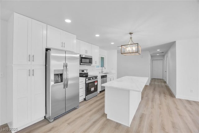 1616 Yellow Rose St, Las Vegas, NV 89108 - kitchen featuring stainless steel appliances, white cabinetry, light wood-style floors, a chandelier, and recessed lighting