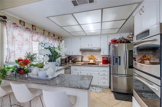 604 N Torrey Pines Dr, Las Vegas, NV 89107 - kitchen with appliances with stainless steel finishes, a peninsula, white cabinets, and under cabinet range hood