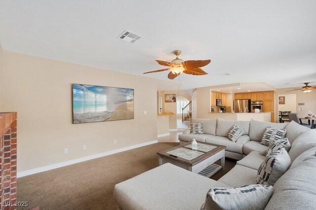 living room with a ceiling fan, carpet floors, and baseboards