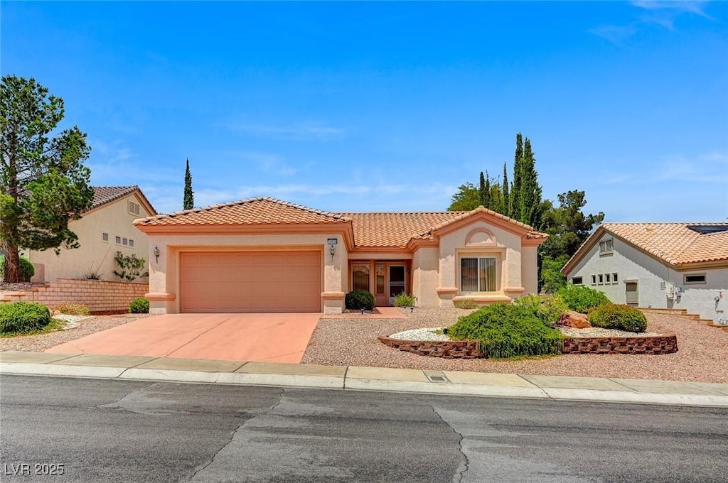10636 Argents Hill Dr, Las Vegas, NV 89134 - mediterranean / spanish house featuring a tiled roof, an attached garage, stucco siding, and driveway