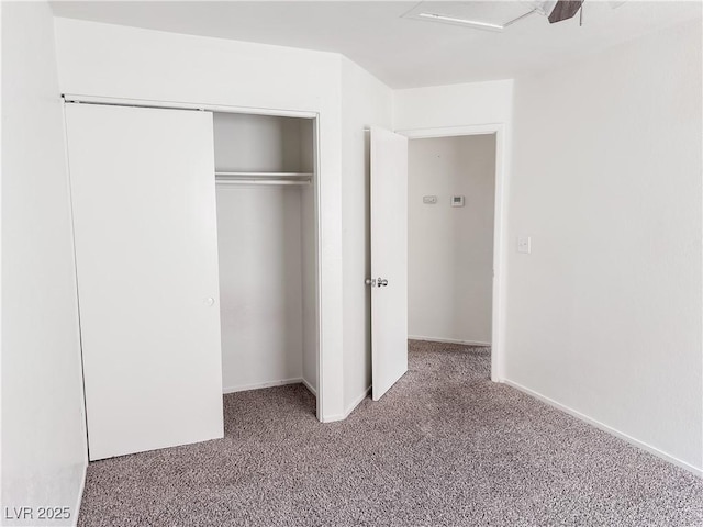 unfurnished bedroom with carpet, a closet, baseboards, and ceiling fan