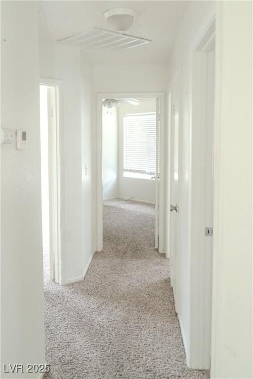 hallway with carpet flooring and baseboards