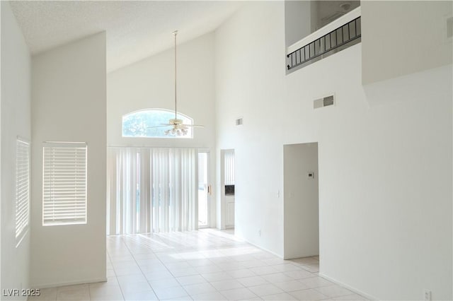 spare room featuring high vaulted ceiling, ceiling fan, baseboards, and light tile patterned flooring