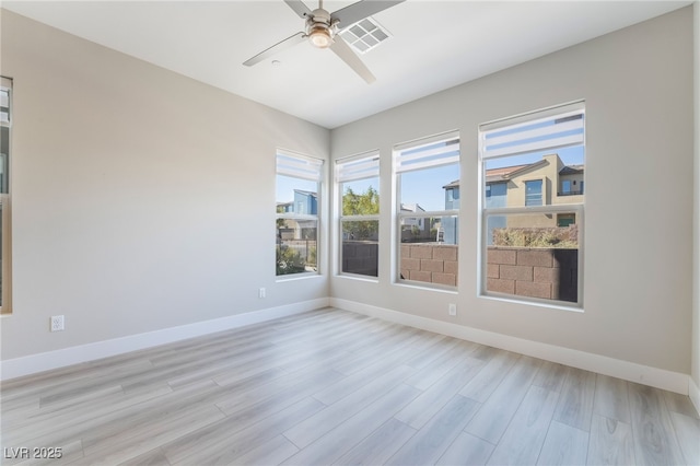 empty room with ceiling fan, baseboards, and light wood finished floors