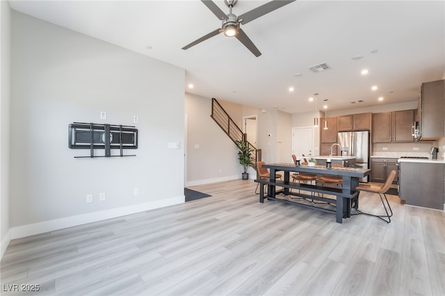 dining room with a ceiling fan, light wood-style floors, baseboards, recessed lighting, and stairway
