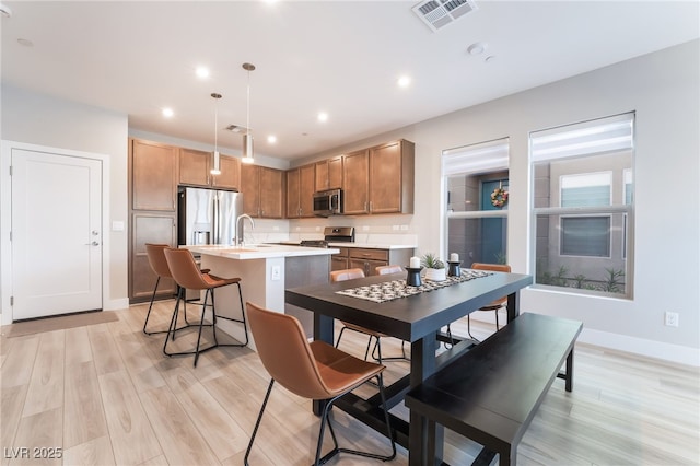 dining area featuring light wood-type flooring, recessed lighting, and baseboards