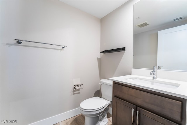 bathroom featuring wood finished floors, vanity, toilet, and baseboards