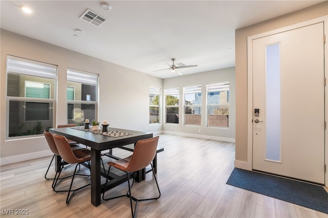 dining room featuring light wood-style flooring, baseboards, and a ceiling fan