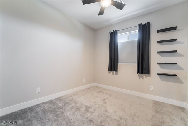 spare room featuring carpet floors, a ceiling fan, and baseboards