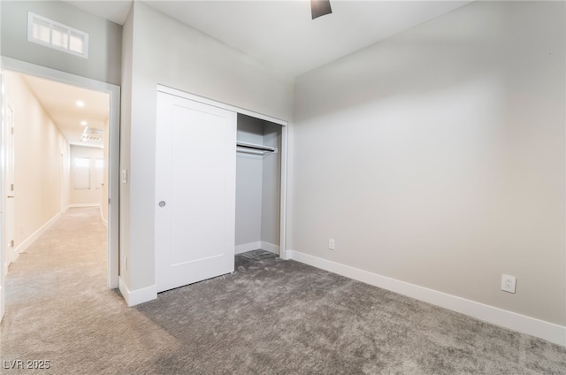 unfurnished bedroom featuring carpet flooring, a closet, baseboards, and a ceiling fan