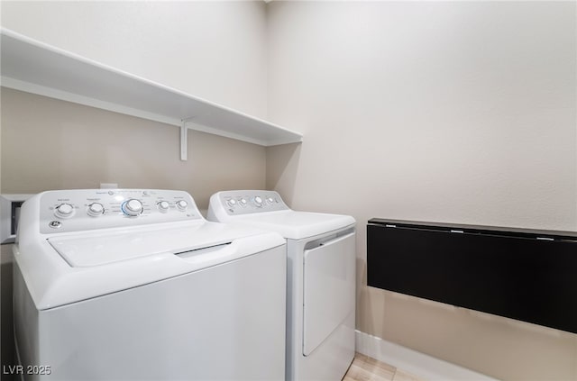 washroom with washer and clothes dryer and baseboards