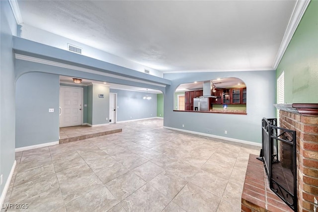 632 Arrayo Way, Boulder City, NV 89005 - unfurnished living room with crown molding, arched walkways, baseboards, light tile patterned floors, and a fireplace
