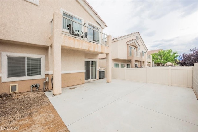 view of patio featuring fence, a balcony, and central air condition unit