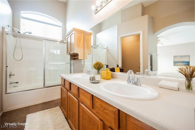 bathroom featuring a ceiling fan, tile patterned flooring, enclosed tub / shower combo, and double vanity