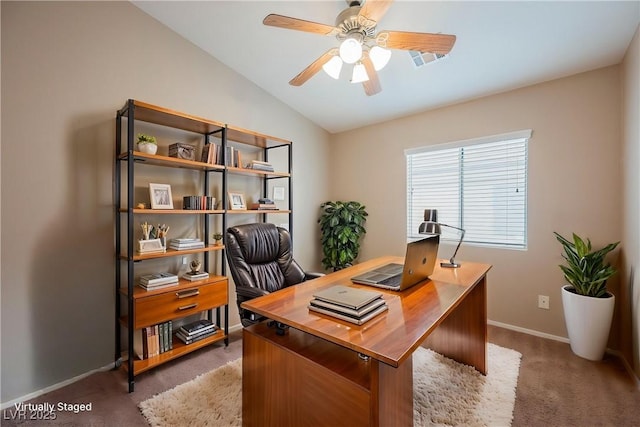 office space with light colored carpet, vaulted ceiling, baseboards, and a ceiling fan