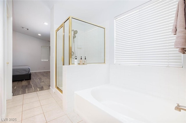 1246 E Gary Ave, Las Vegas, NV 89123 - ensuite bathroom featuring a shower stall, a garden tub, tile patterned floors, and healthy amount of natural light