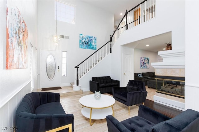 1246 E Gary Ave, Las Vegas, NV 89123 - living area with stairs, wood finished floors, a towering ceiling, a tile fireplace, and recessed lighting