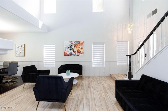 1246 E Gary Ave, Las Vegas, NV 89123 - living room with a towering ceiling, stairway, a wainscoted wall, wood finished floors, and a chandelier