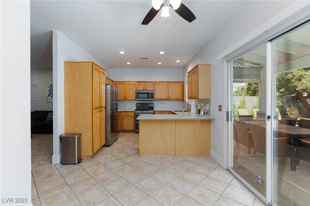 1246 E Gary Ave, Las Vegas, NV 89123 - kitchen featuring appliances with stainless steel finishes, a sink, light countertops, a peninsula, and a ceiling fan