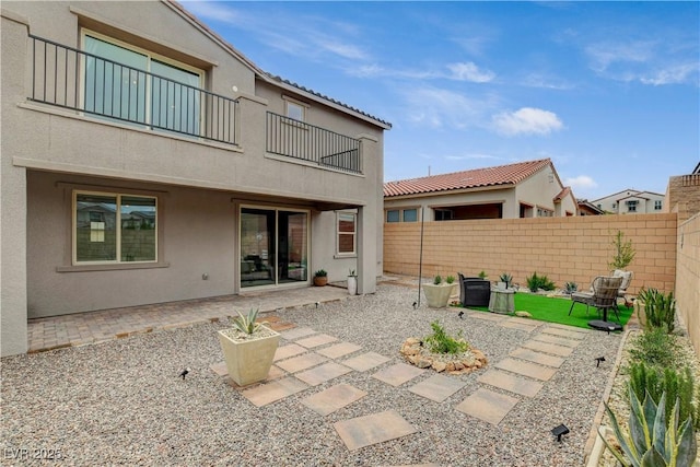 8801 Trotternish Ridge Dr, Las Vegas, NV 89166 - back of house with a balcony, a fenced backyard, stucco siding, and a patio area