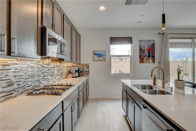 8801 Trotternish Ridge Dr, Las Vegas, NV 89166 - kitchen featuring appliances with stainless steel finishes, a sink, decorative backsplash, baseboards, and recessed lighting
