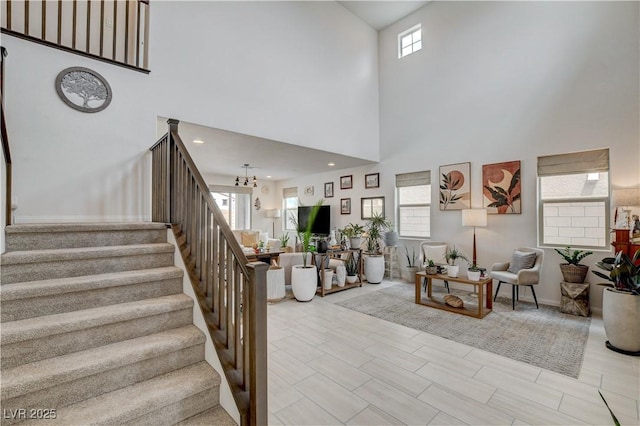 8801 Trotternish Ridge Dr, Las Vegas, NV 89166 - living area with stairway, a high ceiling, a chandelier, and baseboards