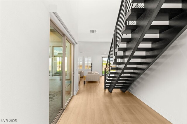 stairway featuring wood finished floors and baseboards