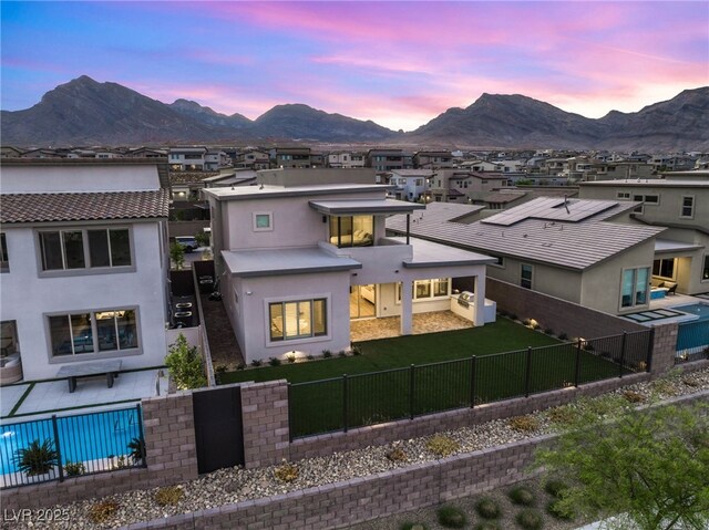 back of house with a mountain view, stucco siding, and a residential view