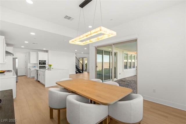 dining area featuring stairway, light wood finished floors, plenty of natural light, recessed lighting, and baseboards