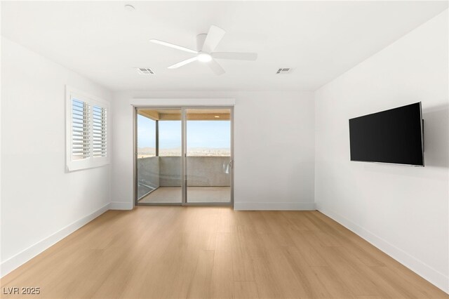 empty room featuring light wood-type flooring, baseboards, and a ceiling fan