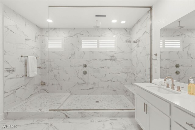bathroom with a marble finish shower, plenty of natural light, marble look tile flooring, and vanity